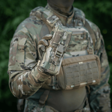 M-Tac Dobbelt Magasin Taske med Fastex Lukning i camouflagedesign holdt af soldat i felten.