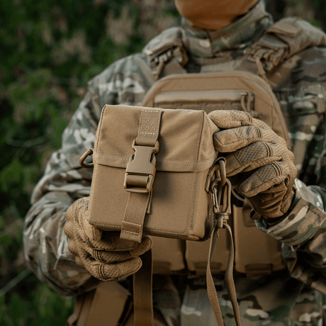 M-Tac Taske til Natkikkert PVS-14 holdt af person i camouflagetøj, designet til sikker opbevaring og nem adgang til udstyr.
