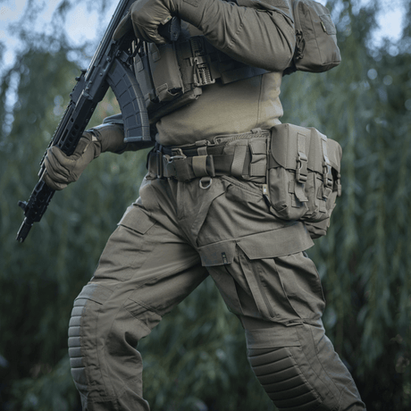 Person iført M-Tac War Belt ARMOR og taktisk udstyr i naturen, klar til kampopgaver