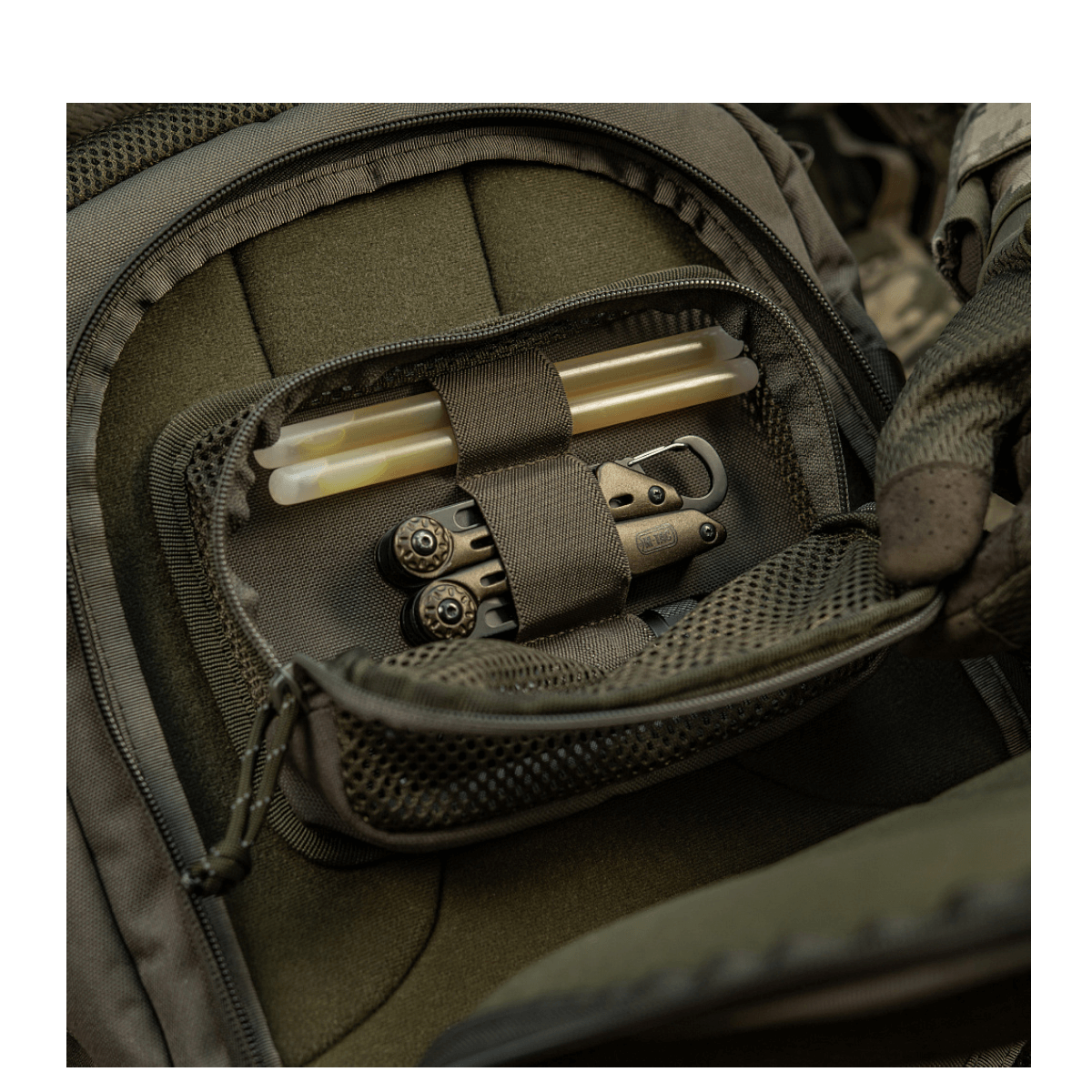 M-Tac Hook & Loop Utility Panel med lynlåslomme til organisering af småting i en taske, vist i en meshlomme i en rygsæk.