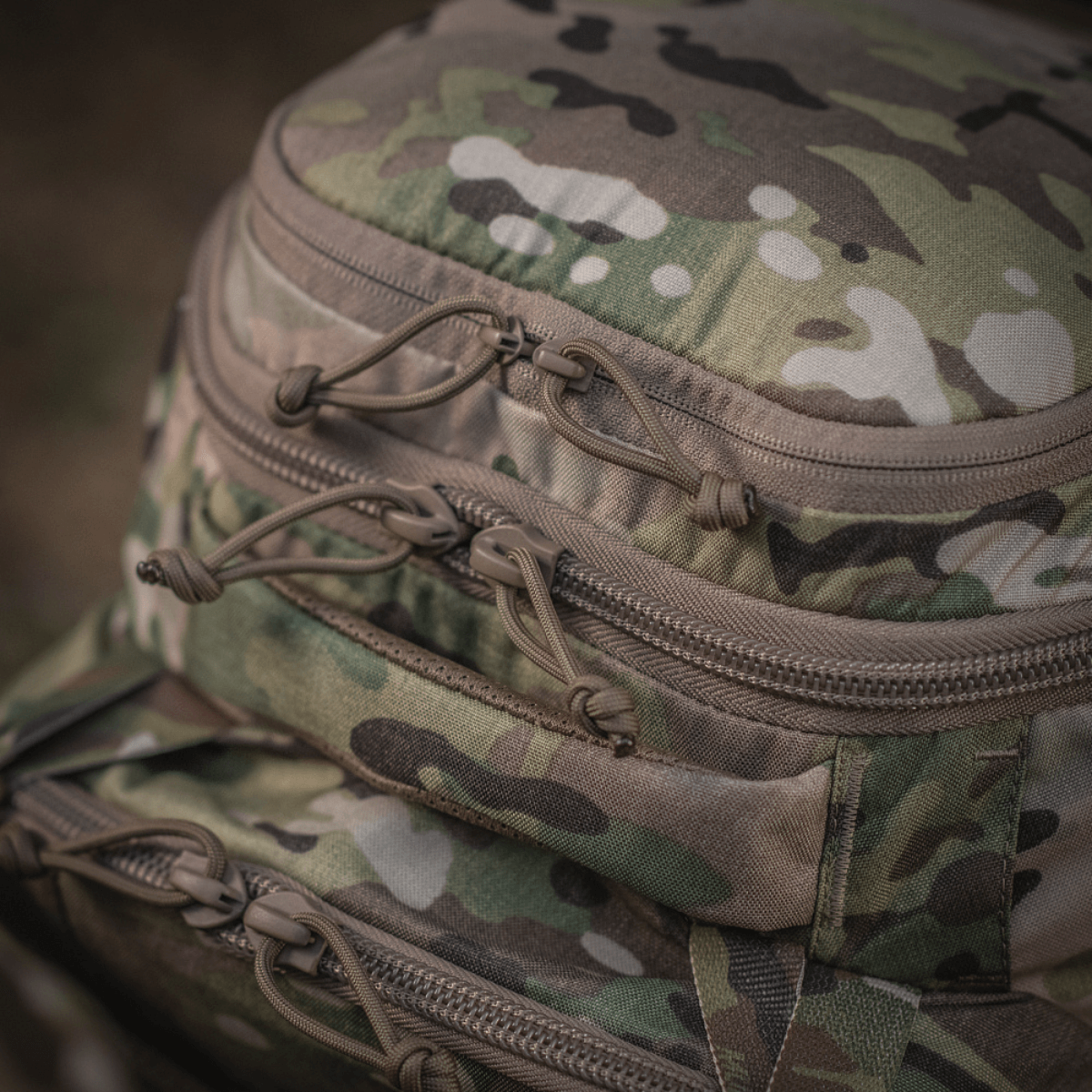 Detaljer af M-Tac Rygsæk Large Gen.IV Elite i camo-design med robuste lynlåse, fremstillet af slidstærk Cordura for holdbarhed.