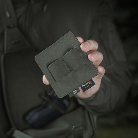 Person holder M-Tac Double Mag Pouch Hook Backed Magazine foran en mørk baggrund