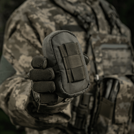 M-Tac PC Utility Pouch Elite i camouflagedragt, Cordura-materiale med MOLLE-interface, vist i militært miljø. Taktisk taske til opbevaring.