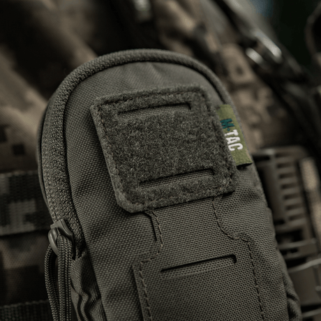 M-Tac PC Utility Pouch Elite med MOLLE-interface og Velcro-panel, 500D Cordura, i nærbillede på en camouflagebaggrund.