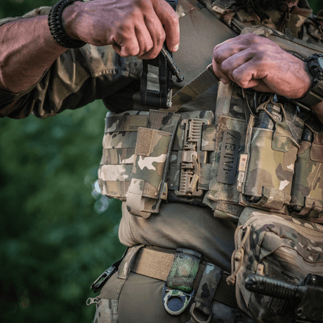 Soldat bærer M-Tac Tourniquet Pouch Elastisk med MOLLE Gen.II på militærudstyr i naturlige omgivelser.