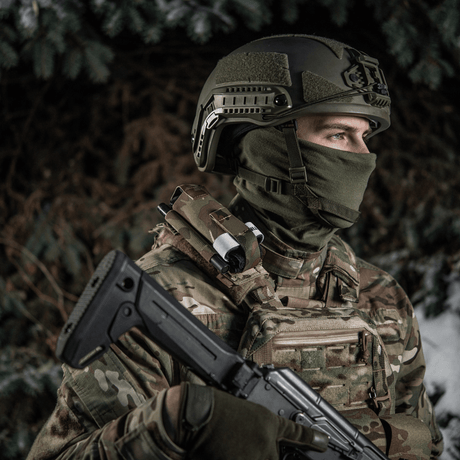 Soldat iført taktisk udstyr med gevær i vintermiljø