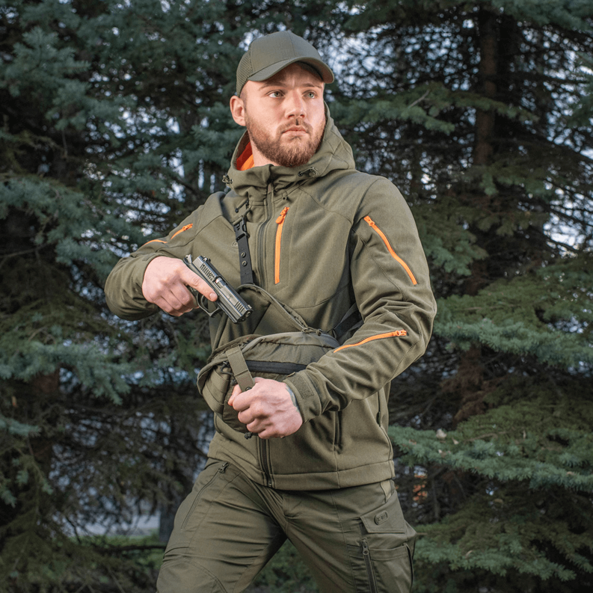 Mand bærer M-Tac Sphaera Hex Hardsling Taske Gen.II Elite i skov, klar til hurtig handling med skjult bæresystem.