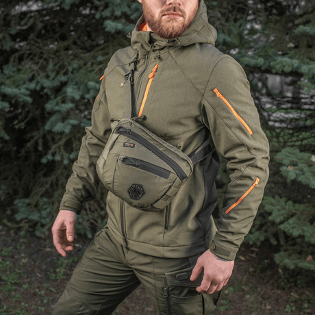 M-Tac Sphaera Hex Hardsling Taske Gen.II Elite på en mand iført militærgrønt tøj i naturen.