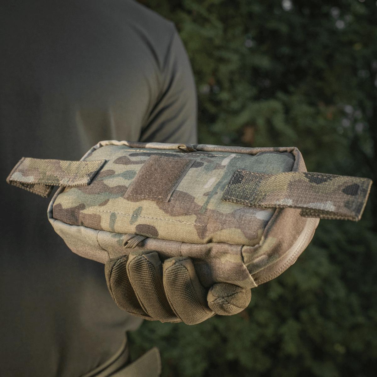 Person holder M‑Tac Horizontal Medical Pouch Elite i camouflage, ideelt til feltbrug og førstehjælp, med robust design og vandtæt lynlås.