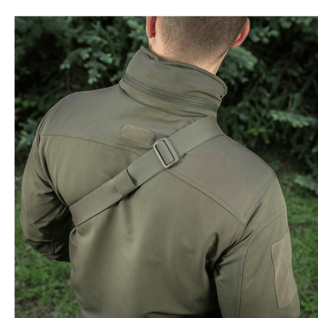 Mand bærer M-Tac Sling Pistoltaske Elite Hex med justerbar skulderrem i en udendørs setting