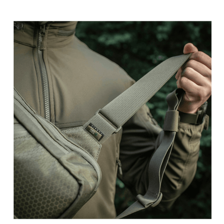 Mand bærer M-Tac Sling Pistoltaske Elite Hex med justerbar skulderrem i Cordura-materiale
