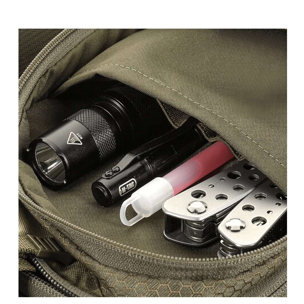 Nærbillede af M-Tac Sling Pistoltaske Elite Hex rummeligt rum fyldt med hverdagslige værktøjer, designet til komfort og alsidig brug.