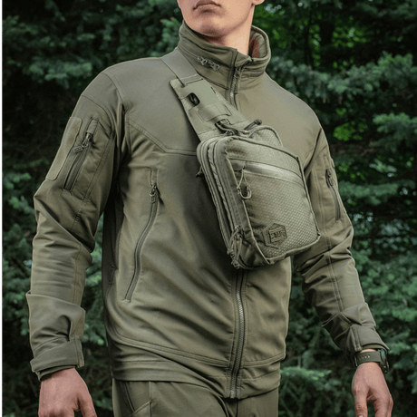 Mand iført M-Tac Sling Pistoltaske Elite Hex, alsidig og stilfuld taske til skjult våben, lavet af holdbart Cordura 1000D materiale.