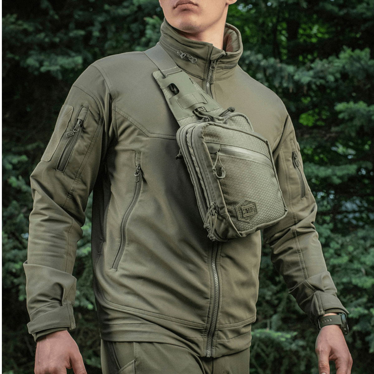 Mand iført M-Tac Sling Pistoltaske Elite Hex, alsidig og stilfuld taske til skjult våben, lavet af holdbart Cordura 1000D materiale.