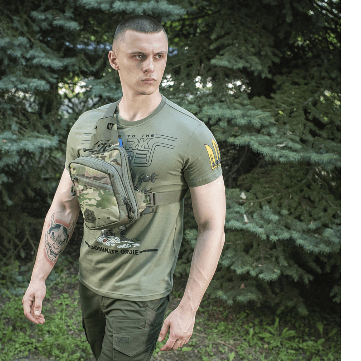 M-Tac Sling Pistoltaske Elite Hex båret af mand i skovrig baggrund. Stilfuld og komfortabel taske til skjult våbentransport.