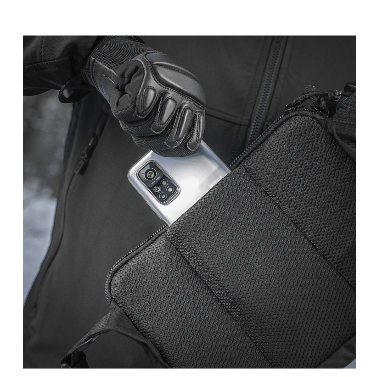 Person tager telefon op af M-Tac Admin Taske Elite lavet af slidstærk Cordura 500D.