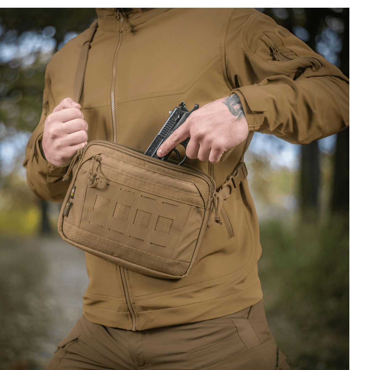 M-Tac Admin Taske Elite fremstillet af Cordura, bæres udendørs af person iført taktisk tøj, viser taskens størrelse og design.