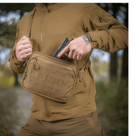 M-Tac Admin Taske Elite fremstillet af Cordura, bæres udendørs af person iført taktisk tøj, viser taskens størrelse og design.