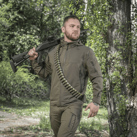 Jæger med M-Tac Bandolier Elite patronbåndelier til 55 skaller, designet til hurtig adgang til ammunition under jagt.