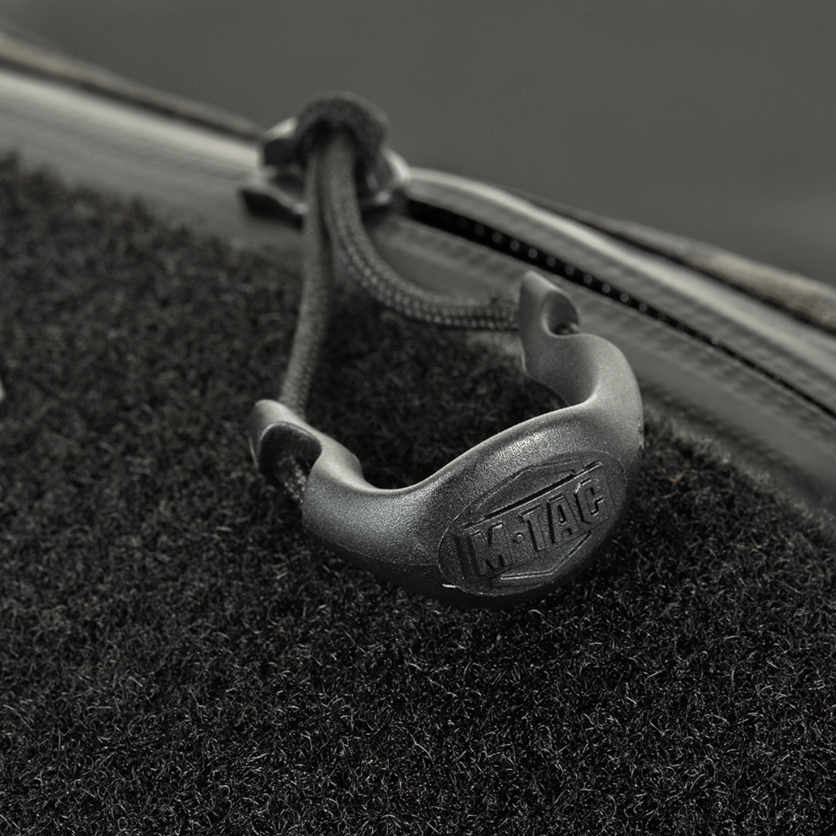 Nærbillede af M‑Tac Bæltetaske Elite Hex med lynlås og logo, detaljeret syning på stilfuldt design.