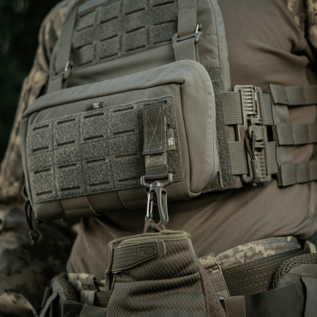 M-Tac Karabinhage Tilbehør fastgjort på taktisk vest med MOLLE-system, ideelt til udstyrssikring og justerbarhed.