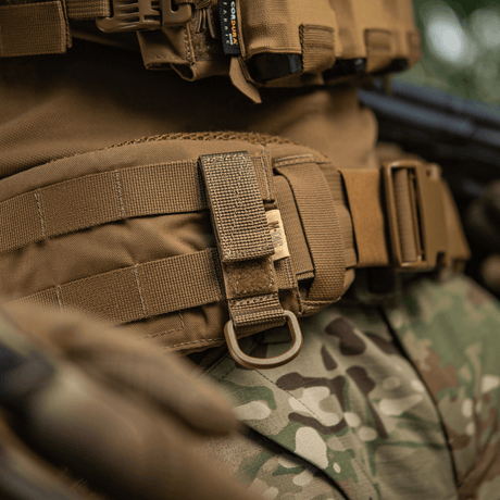 M-Tac Fastgørelse med D-ring til MOLLE-system på taktisk udstyr, viser sikker ophængning og justerbar Velcro-lukning.