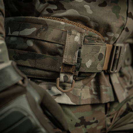 M-Tac Fastgørelse med D-ring på taktisk MOLLE-bælte i camouflagemønster, ideel til montering af udstyr med Velcro-lukning.