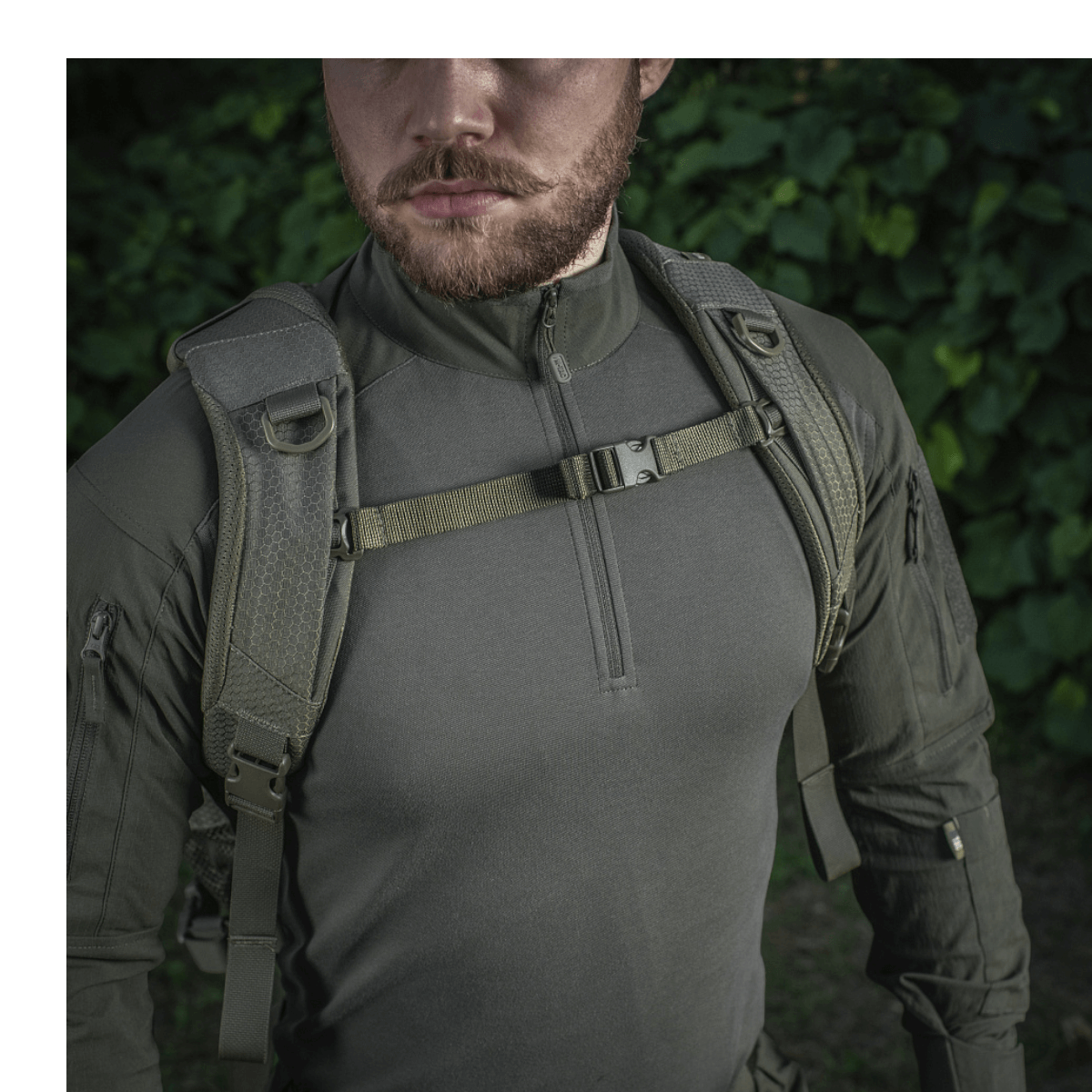 Mand bærer M-Tac Mission Rygsæk Elite Hex med MOLLE-system i naturen. Holdbar Cordura materiale.