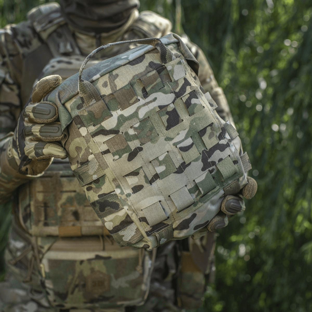 M-Tac Sukharka Gen.3 Pouch i camouflage design med MOLLE-interface, holdt af soldat i militær uniform. Robust Cordura 500D materiale.