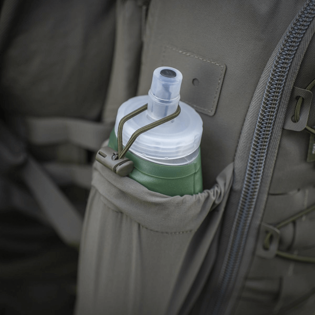 M-Tac STURM Elite Rygsæk med elastisk sidelomme, der holder en vandflaske, lavet af holdbart Cordura-materiale til taktisk brug.