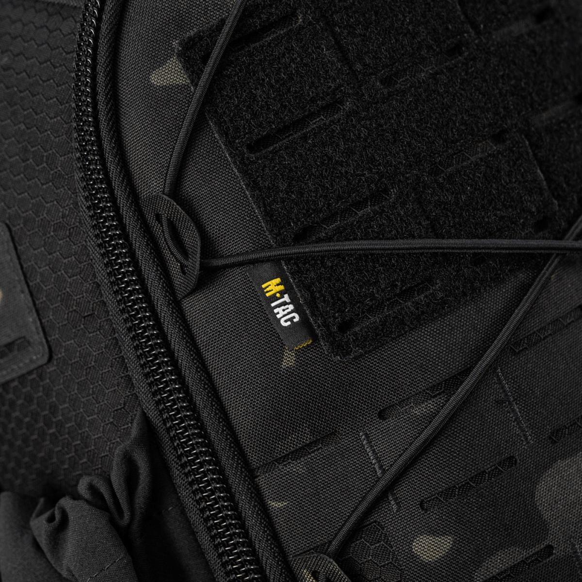 Sort taktisk taske med lynlås og M-Tac mærke, tæt på visning af stropper og velcro.