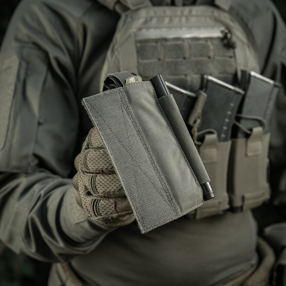 Taktisk udstyr med M‑Tac Tourniquet Pouch Elastic Gen.5 holdende CAT tourniquet, elastisk bånd og velcro på en plate carrier