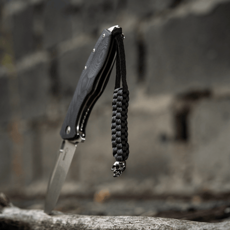 Sort M-Tac Knife Lanyard Cuboid Skull paracord med dekorativ Cuboid Skull-perle, flettet til kniv for unikt udtryk og praktisk brug.