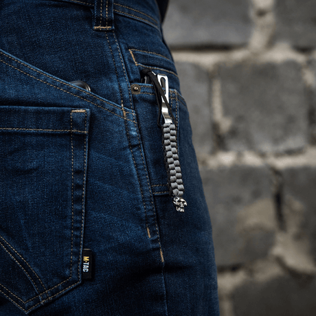 M-Tac Knife Lanyard Cuboid Skull fastgjort til jeans med paracord-flettet design og dekorativ kraniumperle.