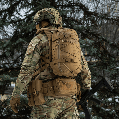 M-Tac Rygsæk Sturm Elite Gen.II i felten, mand i camouflagetøj og taktisk rygsæk med MOLLE system og forstærkede stropper, skovmiljø