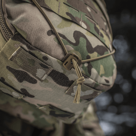 Nærbillede af M-Tac Rygsæk Sturm Elite Gen.II med camouflage mønster og bungee snøring til udendørsudstyr.