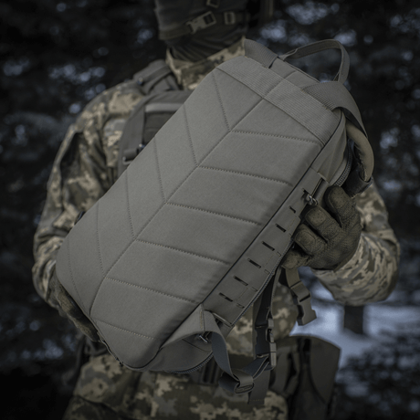 Taktisk M-Tac Rygsæk Sturm Elite Gen.II holdt af en person i camouflageudstyr.