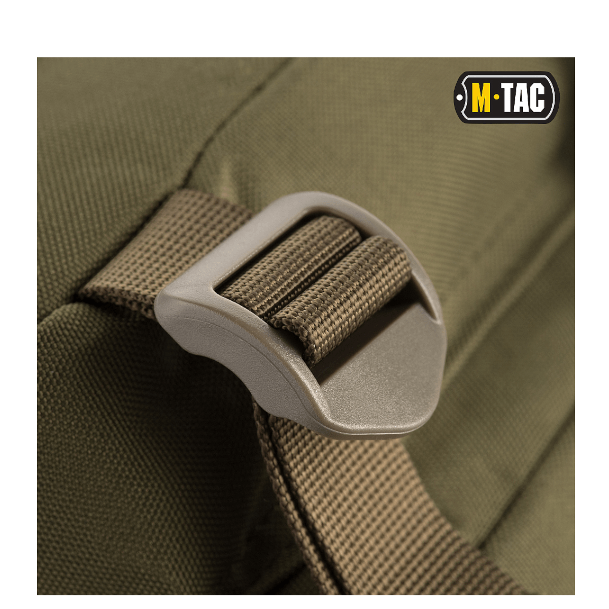 Nærbillede af spænde på M-Tac Assault Pack, en byrygsæk med MOLLE-system og justerbare skulderremme, ideel til vandreture.