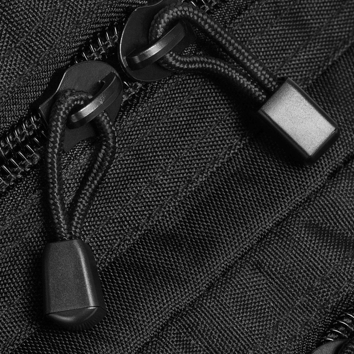 Nærbillede af lynlåsstropper på M-Tac Assault Pack Laser Cut rygsæk i slidstærkt polyester med MOLLE-system.