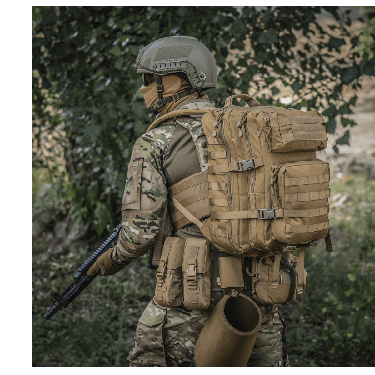 M-Tac Large Assault Pack Rygsæk monteret på en soldats ryg, udstyret med MOLLE-system og polstrede stropper for komfortabel bæring.