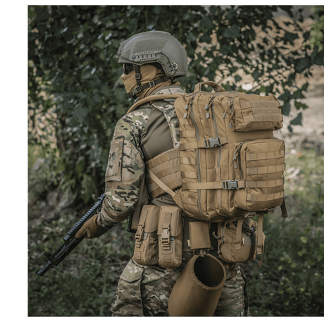 M-Tac Large Assault Pack Rygsæk med MOLLE-system, bæres af person i camouflageuniform under træer