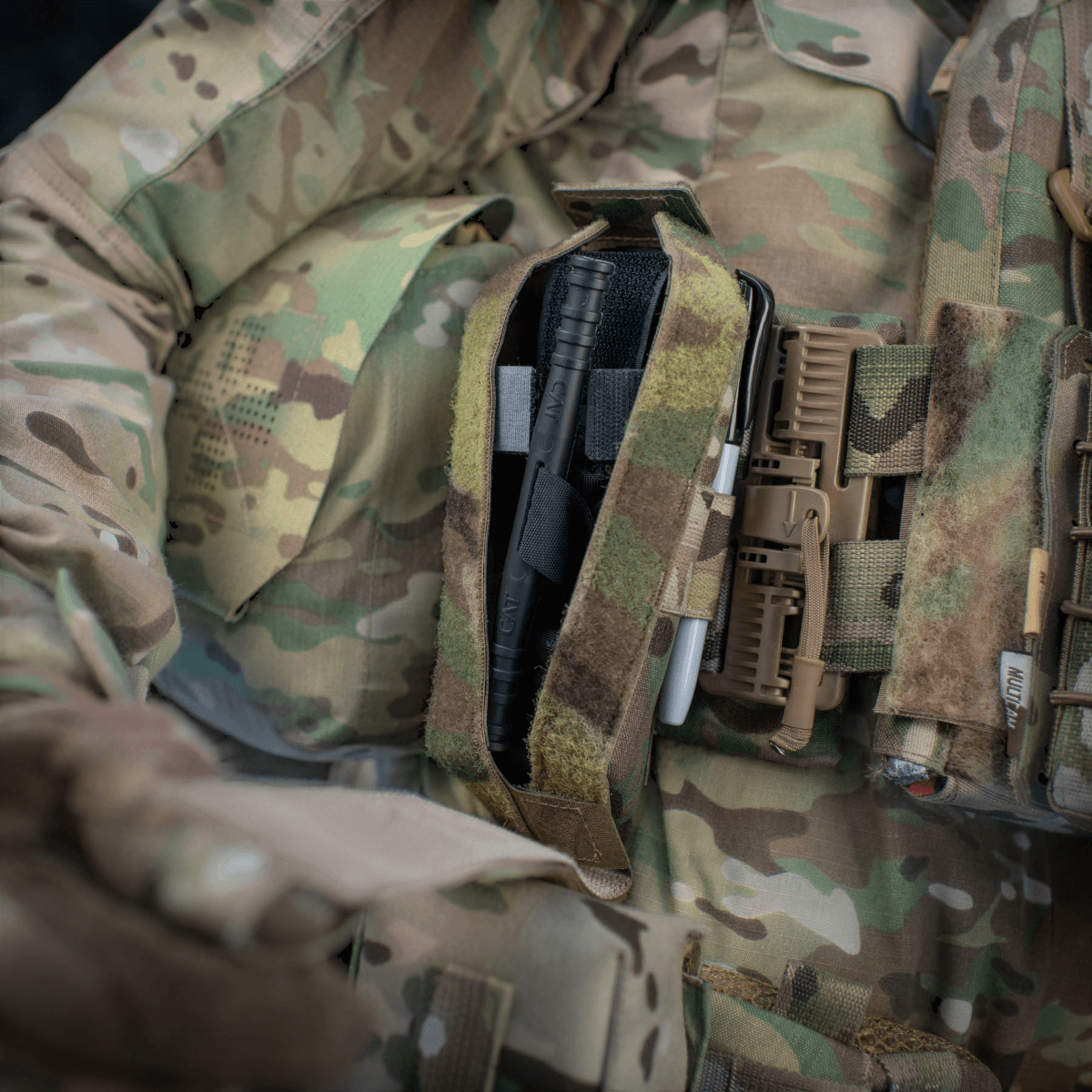 M-Tac Lomme til Tourniquet Closed monteret på camouflageuniform for optimal førstehjælpsbeskyttelse i nødssituationer.