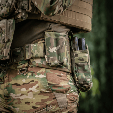 M‑Tac Double Magazine Pouch APS Laser Cut fastgjort til en taktisk bælte med camouflagedesign, viser robust Cordura-materiale og MOLLE montering.