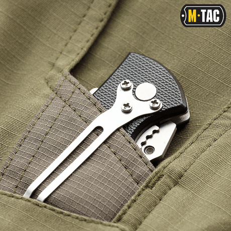 Lomme på M-Tac Shorts Aggressor Short med værktøj fastgjort, viser holdbarhed og praktiske funktioner til taktisk brug.