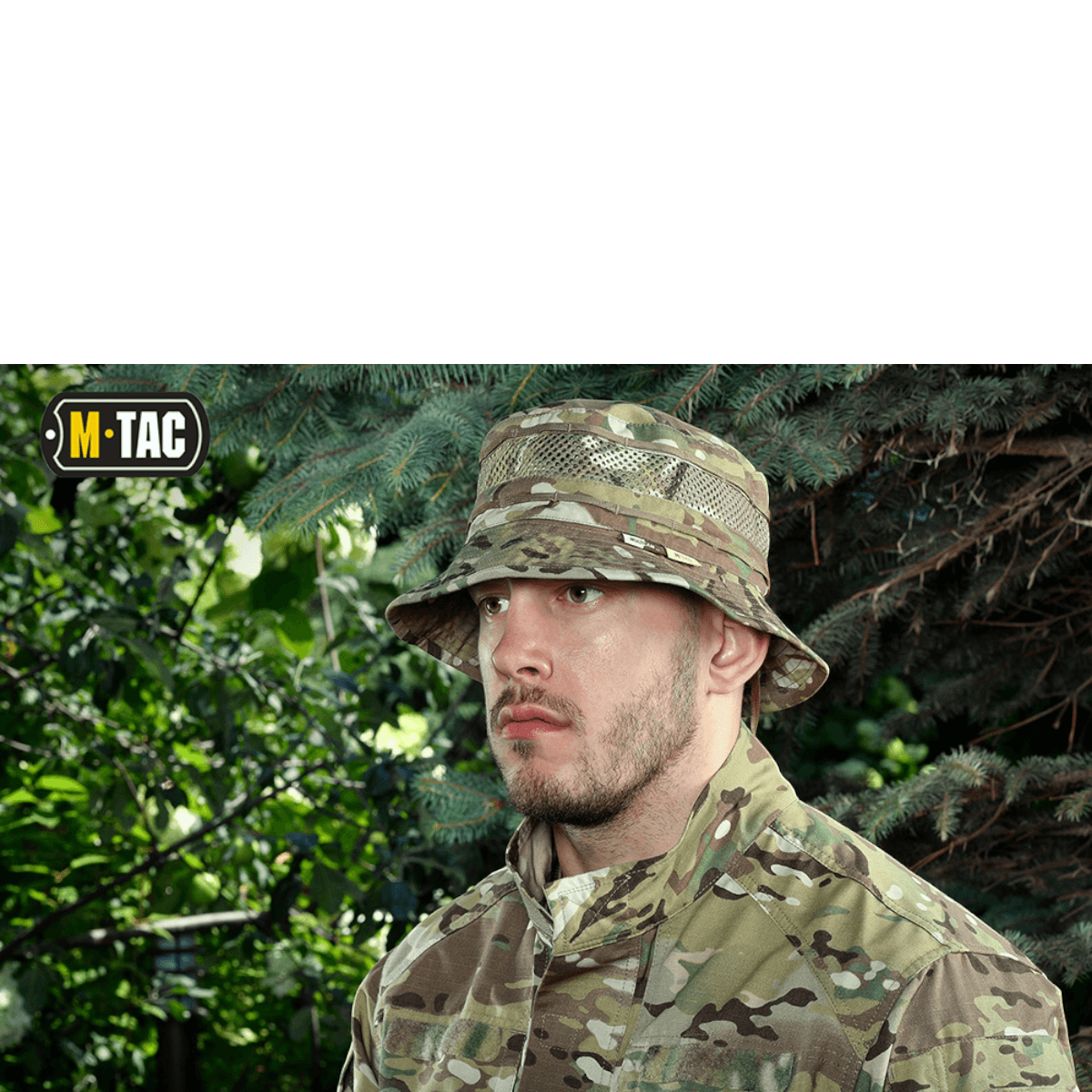 Mand iført M-Tac Panamahat med Net Elite NYCO blandt træer, med camouflage og justerbar snor til at sikre ved blæsevejr.