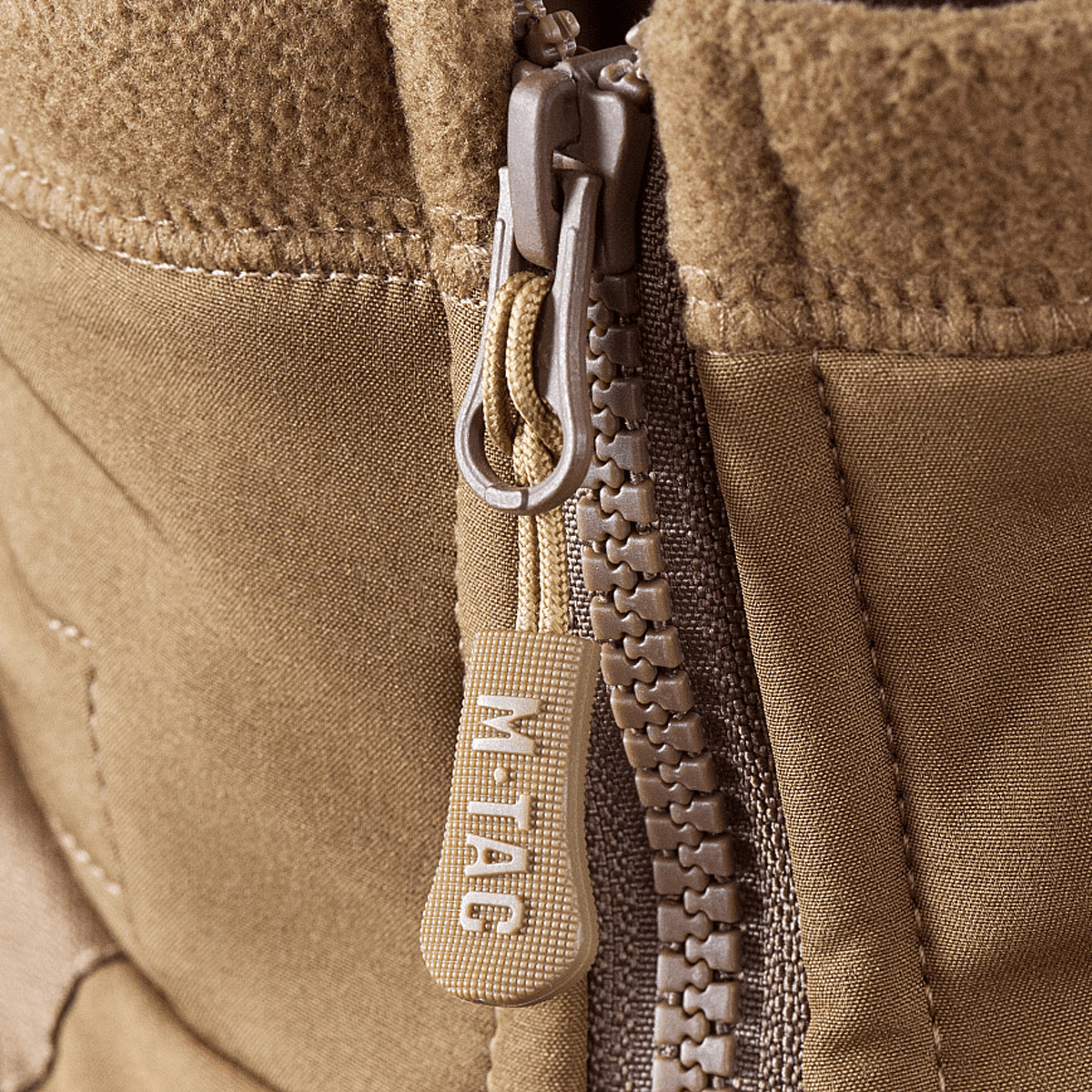 Nærbillede af lynlås på M-Tac Norman Windblock Fleecejakke, viser WindBlock-materiale med Softshell-indlæg i beige farve.
