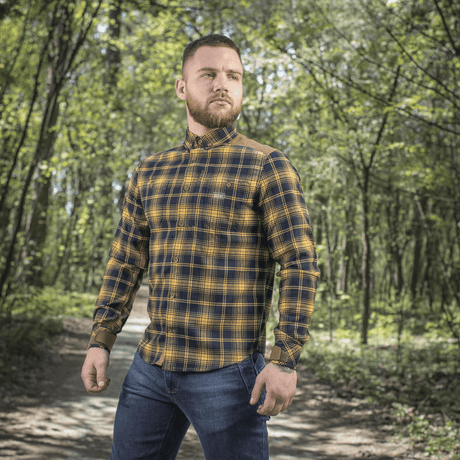 Mand iført M-Tac Redneck Skjorte i navy blue/yellow skovmiljø. Klassisk plaid-design med justerbare ærmer, perfekt til fritid.