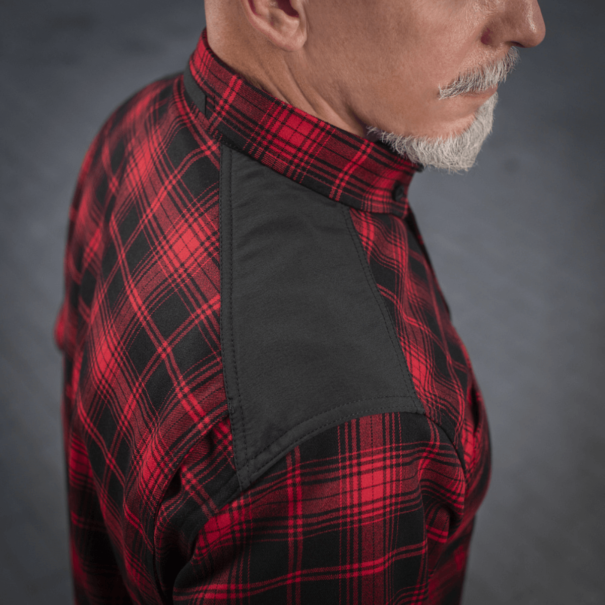 Mand iført M-Tac Redneck Skjorte i rød/sort, vist fra siden med forstærkede skuldre og særligt design. Ideel til arbejde og fritid.