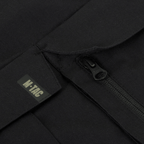 Close-up af M-Tac Bukser STURM NyCo Extreme Gen.II lynlås med M-Tac logo, fremhæver holdbarhed og design.