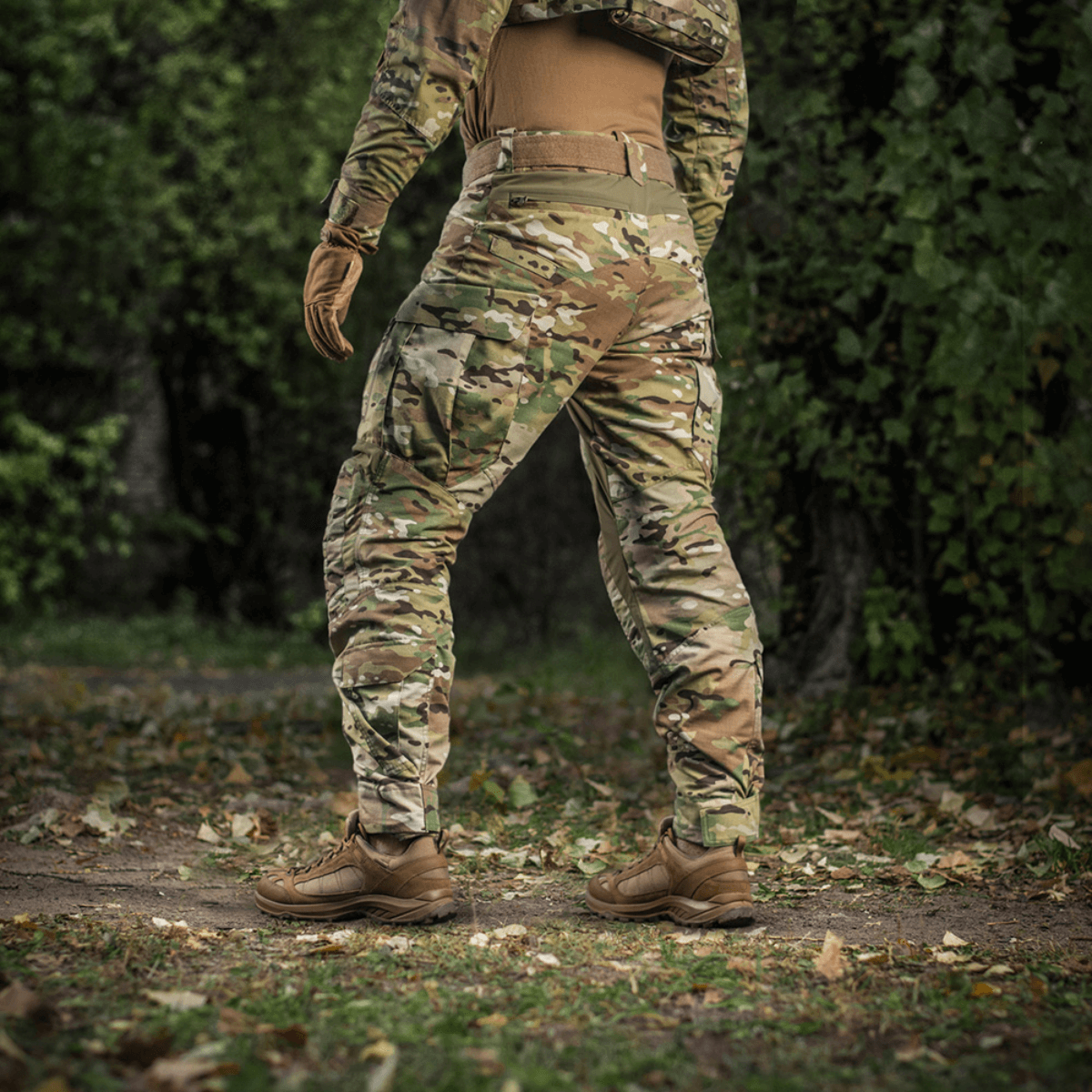 Person iført M-Tac Bukser STURM NyCo Extreme Gen.II med camouflage design i skovmiljø.
